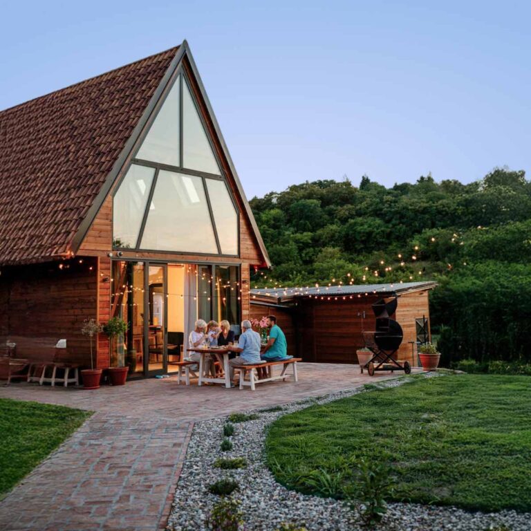 Nice home out in the country with people sitting around a table