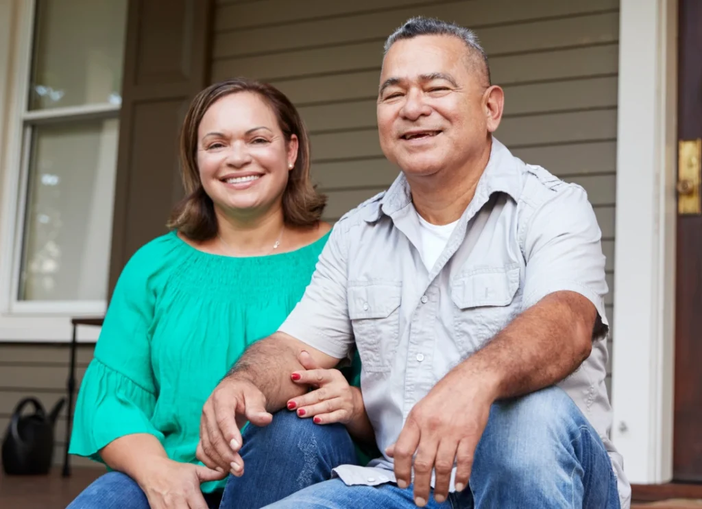 Couple smiling while sitting on porch steps